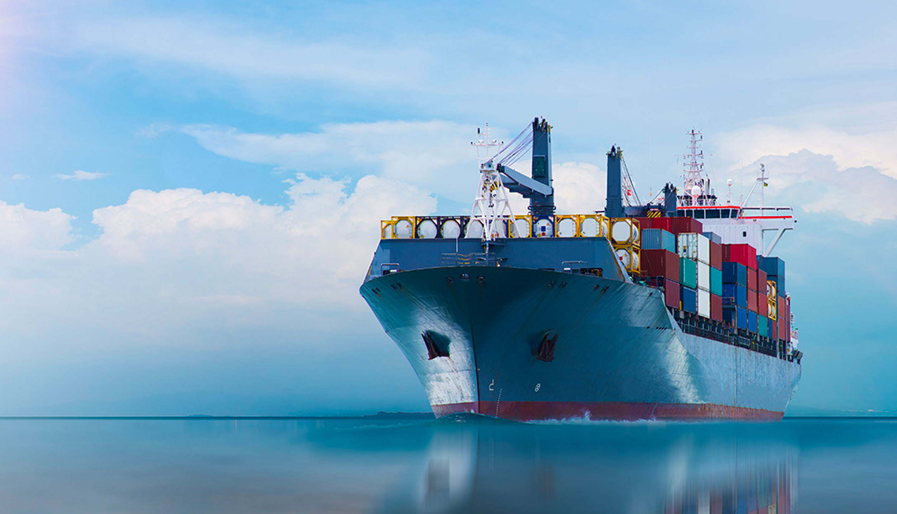 Cargo ship at sea at sunset